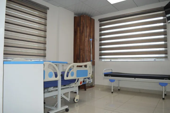 A patient room with a bed, wardrobe and a separate couch for the attending family member