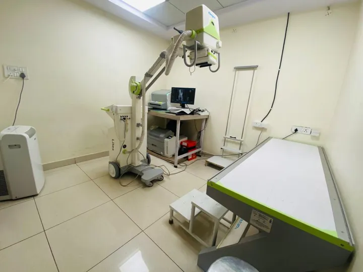 The digital X-ray room, with the ceiling-mounted tube over the patient table and images on the reporting monitor