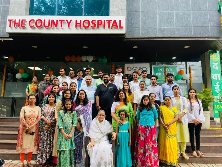 The hospital staff gathered on the front steps under The County Hospital sign for a group photograph