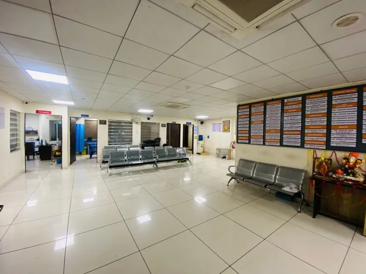 The main waiting area, with the consultant name boards on the right and the emergency entrance at the far end