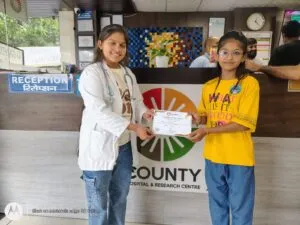 A doctor handing a schoolgirl her certificate at the reception counter
