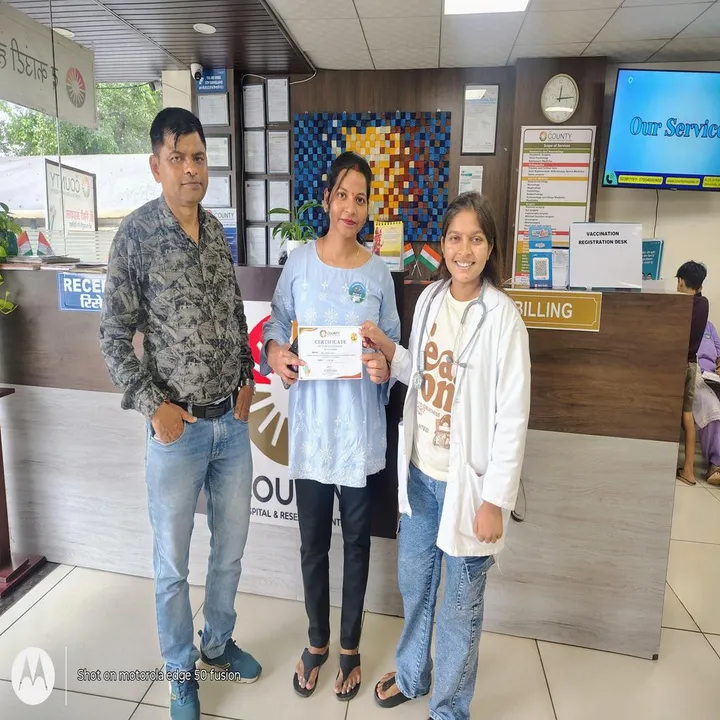 A couple with their certificate beside a doctor, in front of the vaccination registration desk